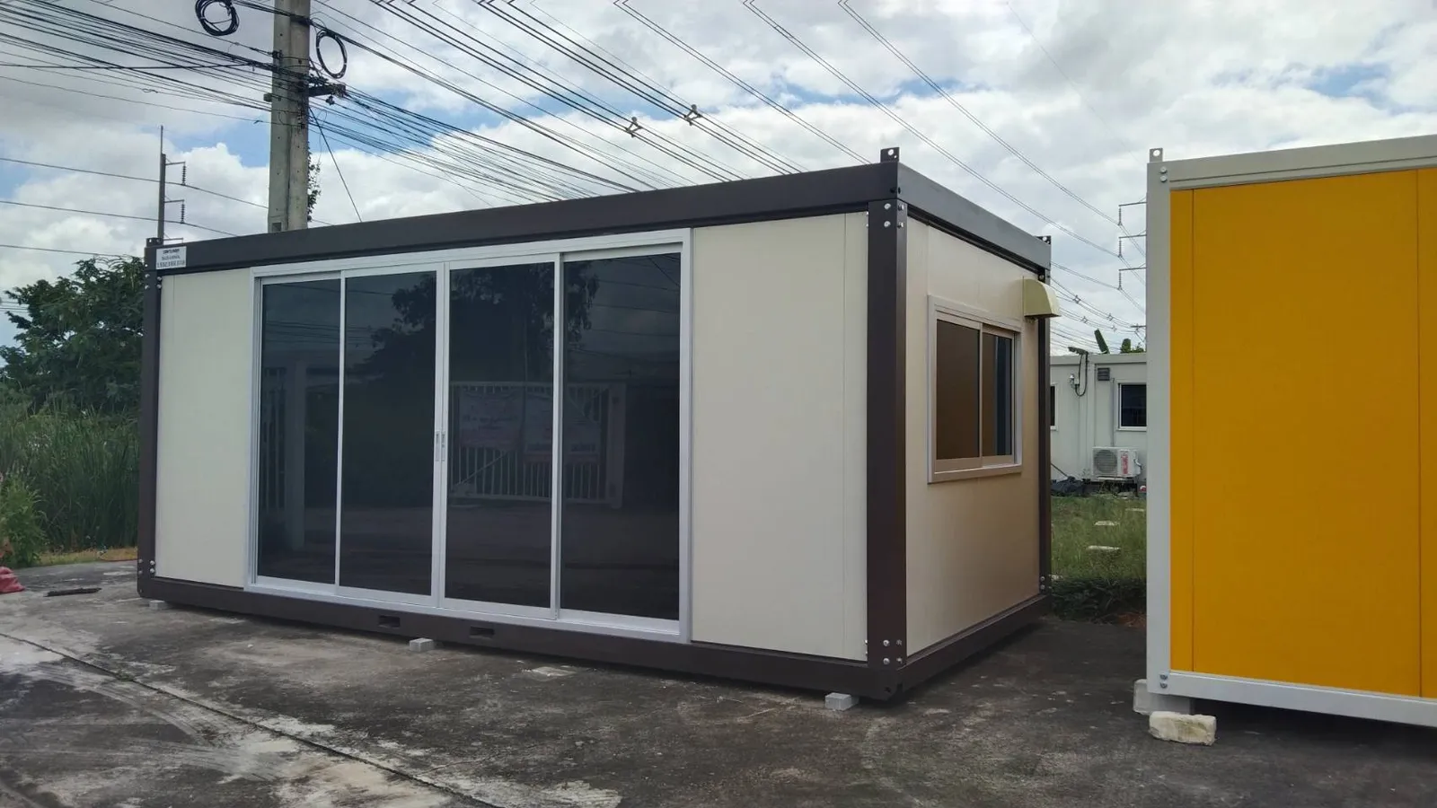 Knock-down office unit with cream walls, dark-brown frame and four sliding glass doors
