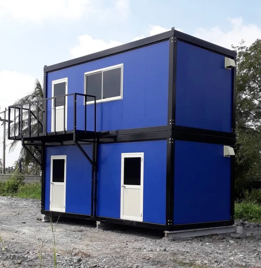 Two-storey blue knock-down worker housing with external steel stair, balcony and separate doors