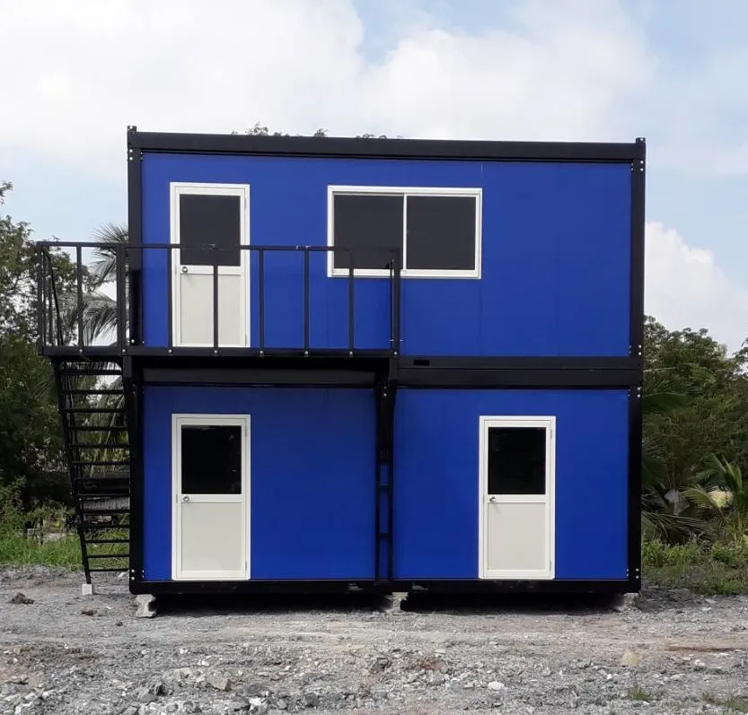 Two-storey blue knock-down worker housing with external steel stair, balcony and separate doors (view 2)