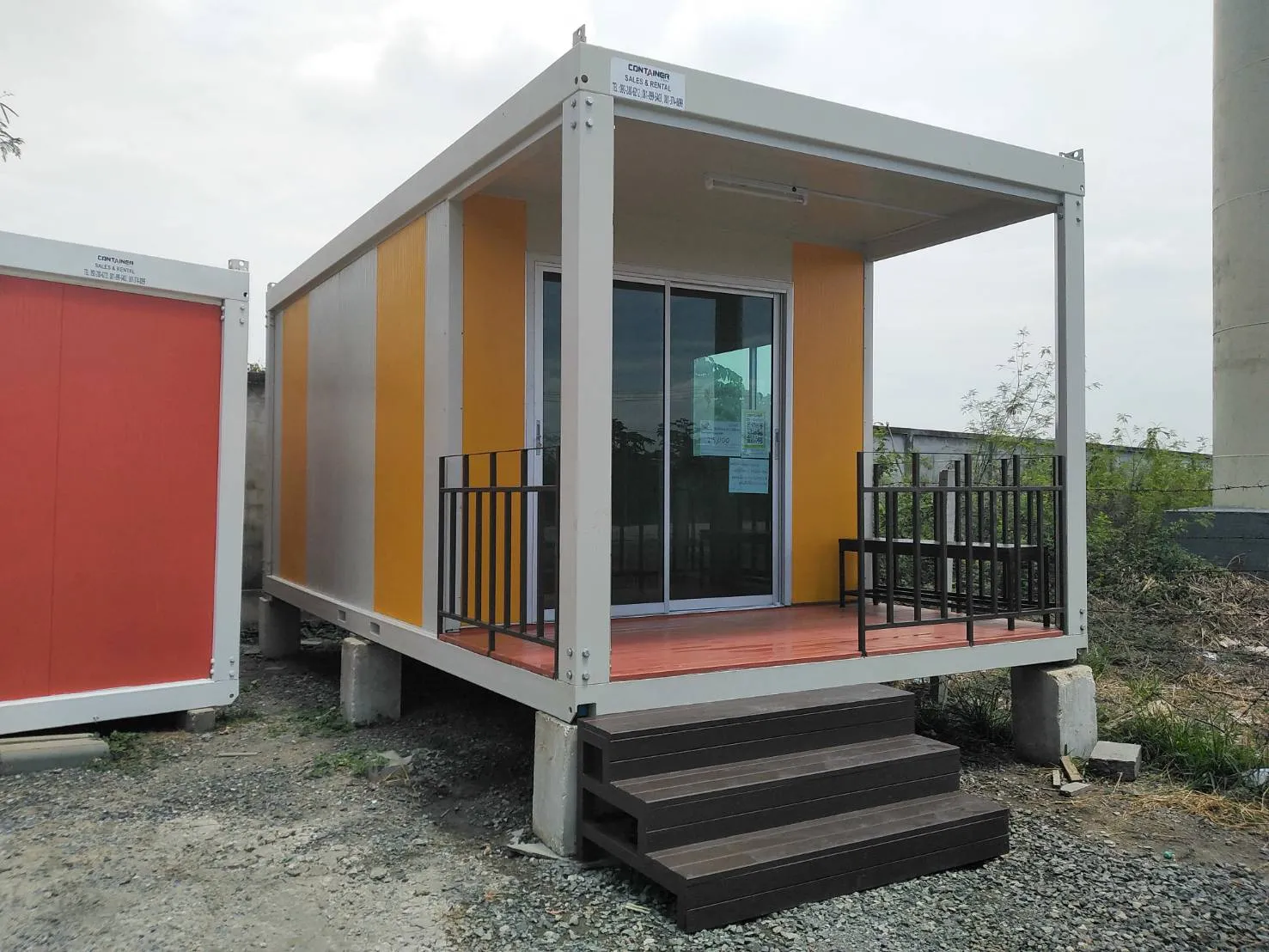 Single yellow knock-down unit with a wooden deck, steel railing and timber steps, resort style